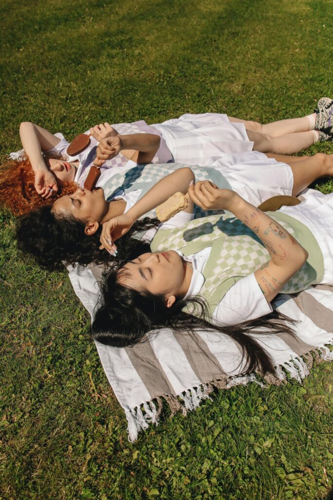 2024 Summer - photo of three women eating ice cream, lying on the grass